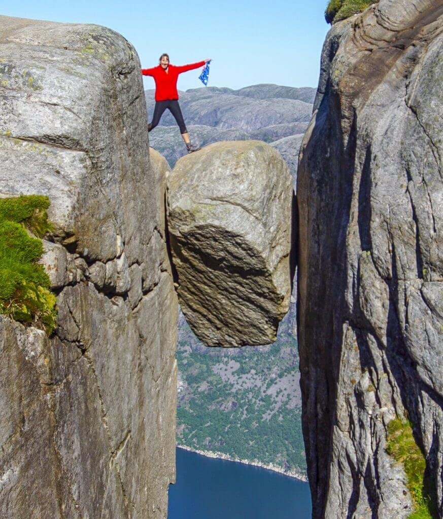 A man standing on the wedge of Kjeragbolten best hiking tours in norway