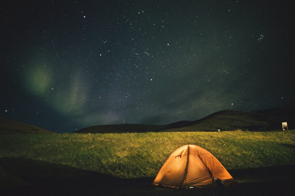 Tent in field with Northern lights above